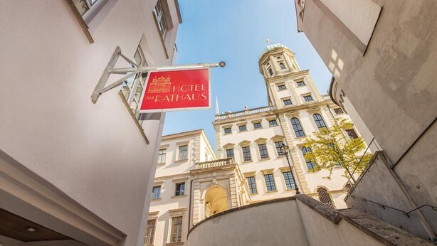 Een hotelschild met de naam 'HOTEL MATHAUS' in een Europese stad.