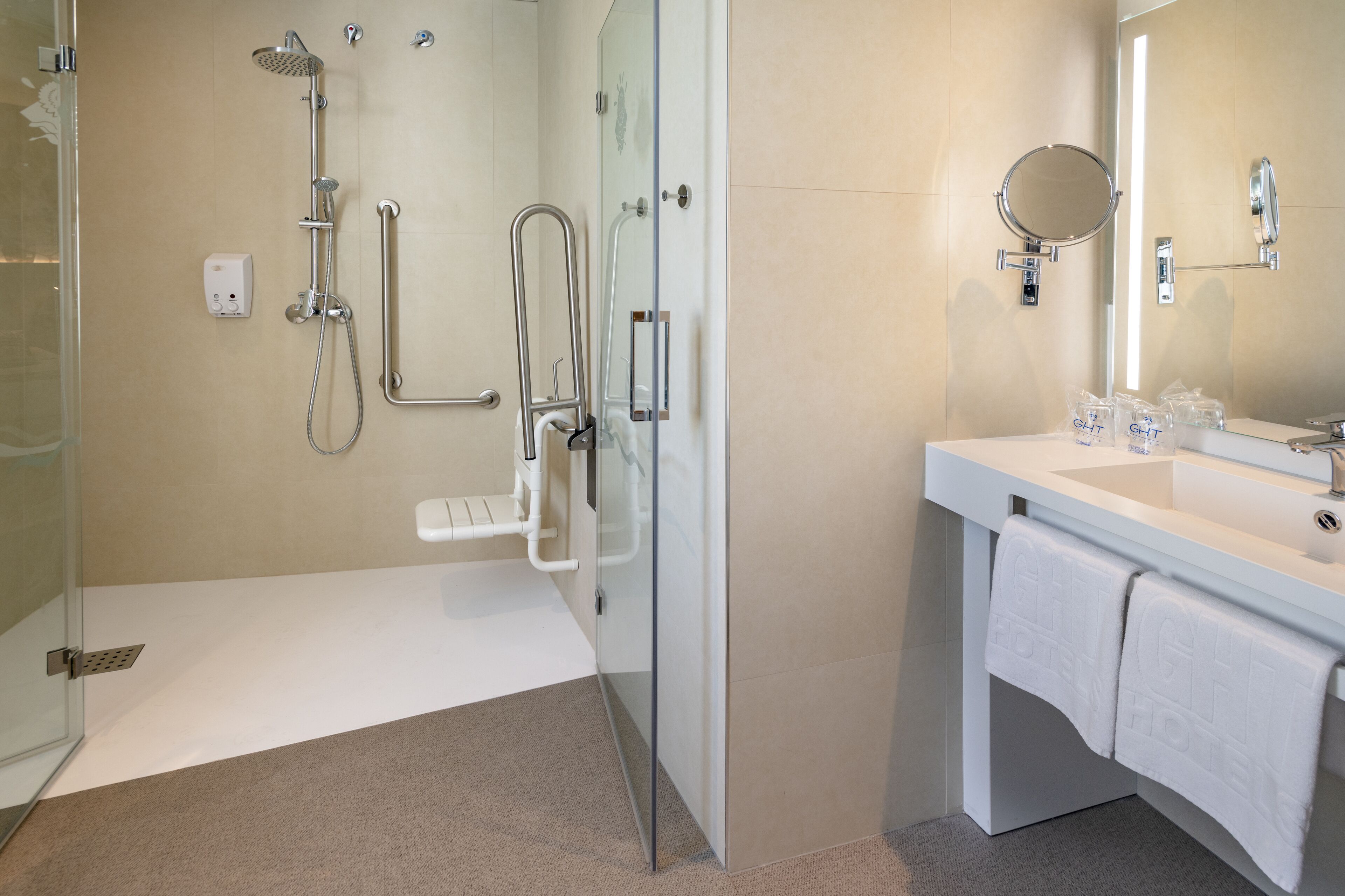 A modern bathroom with a glass shower enclosure, a white sink with a mirror, and a towel rack.