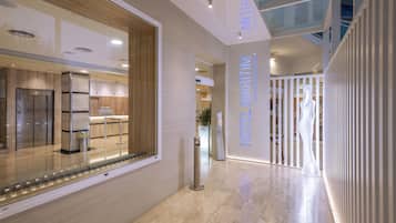 Welcome to our hotel lobby, featuring a reception desk, elevator, and polished floors.