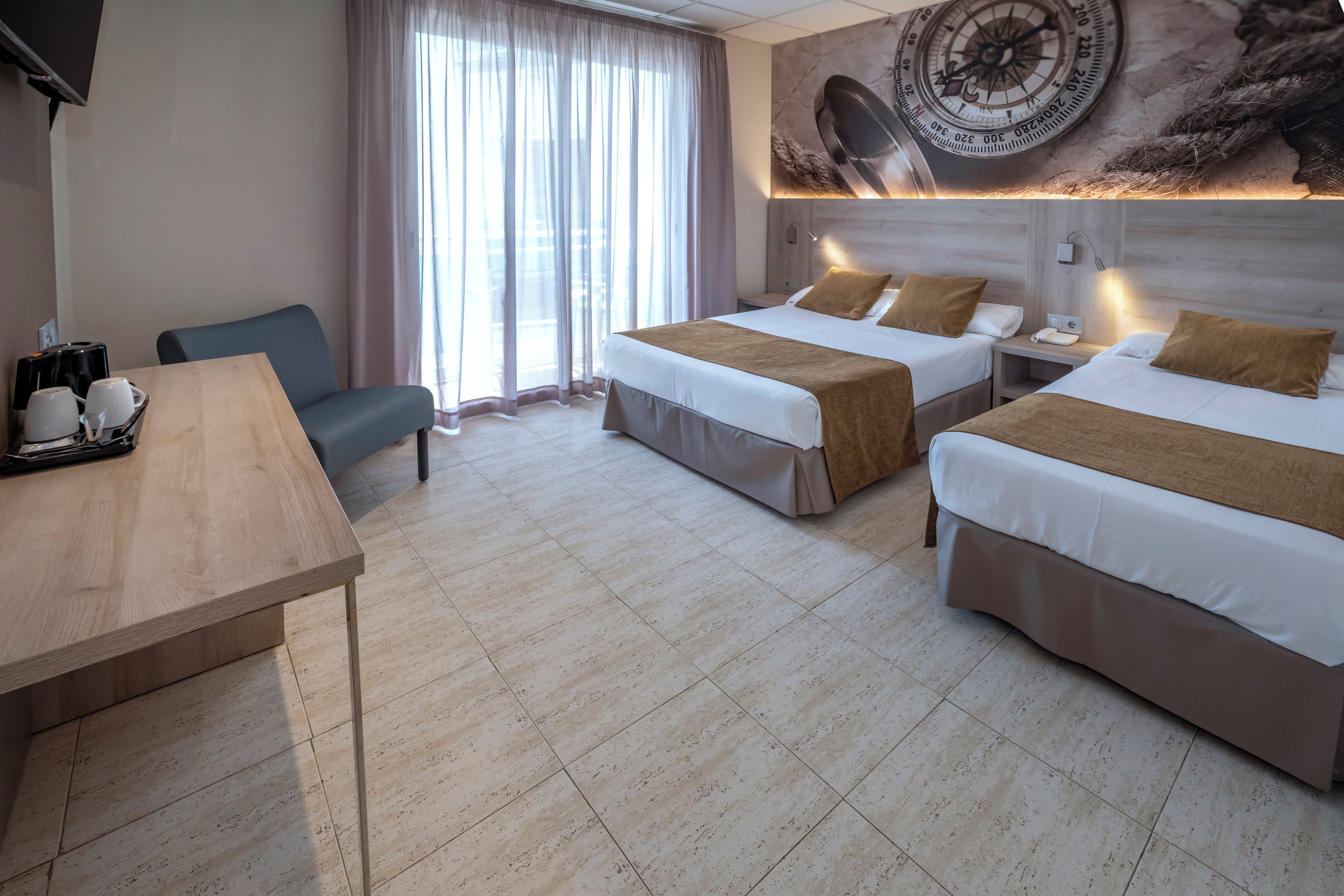 Ein Hotelzimmer mit zwei Betten, einem Schreibtisch, einem Stuhl und einer großen Wanduhr.