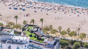 Ett hotell med flera balkonger med utsikt över en strand.