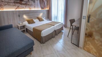 Una habitación de hotel con una cama grande, una cama más pequeña, un escritorio y una silla.