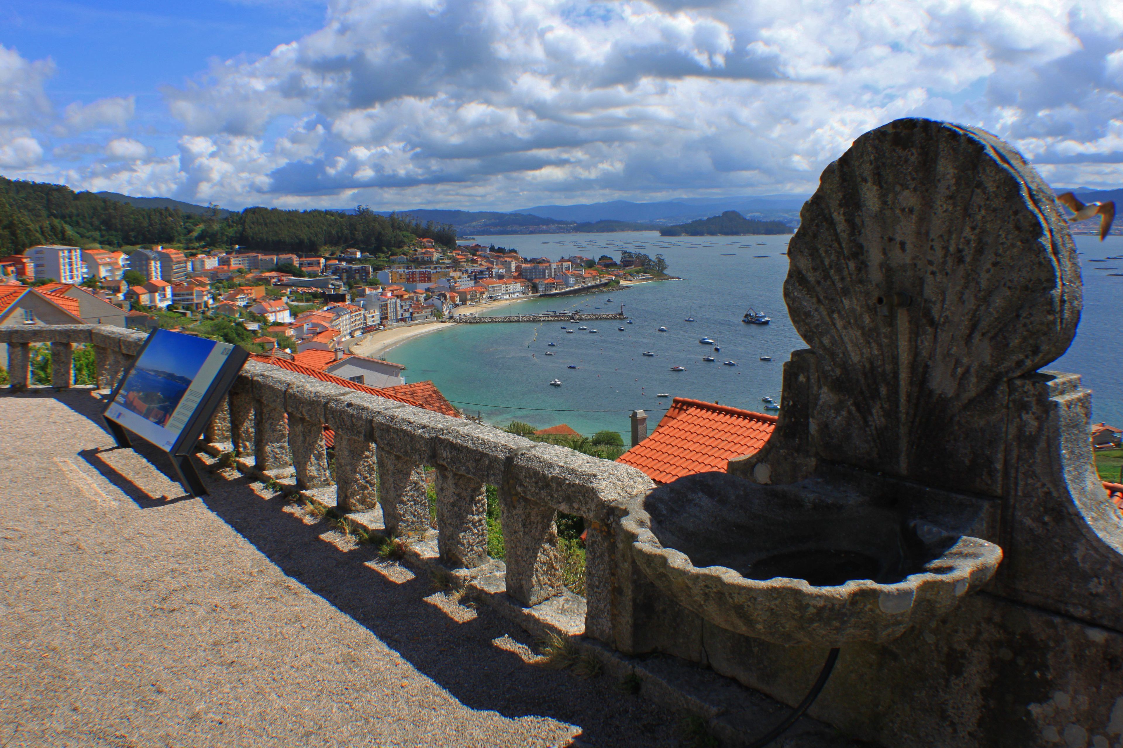 A coastal town with a stone structure and a signboard.