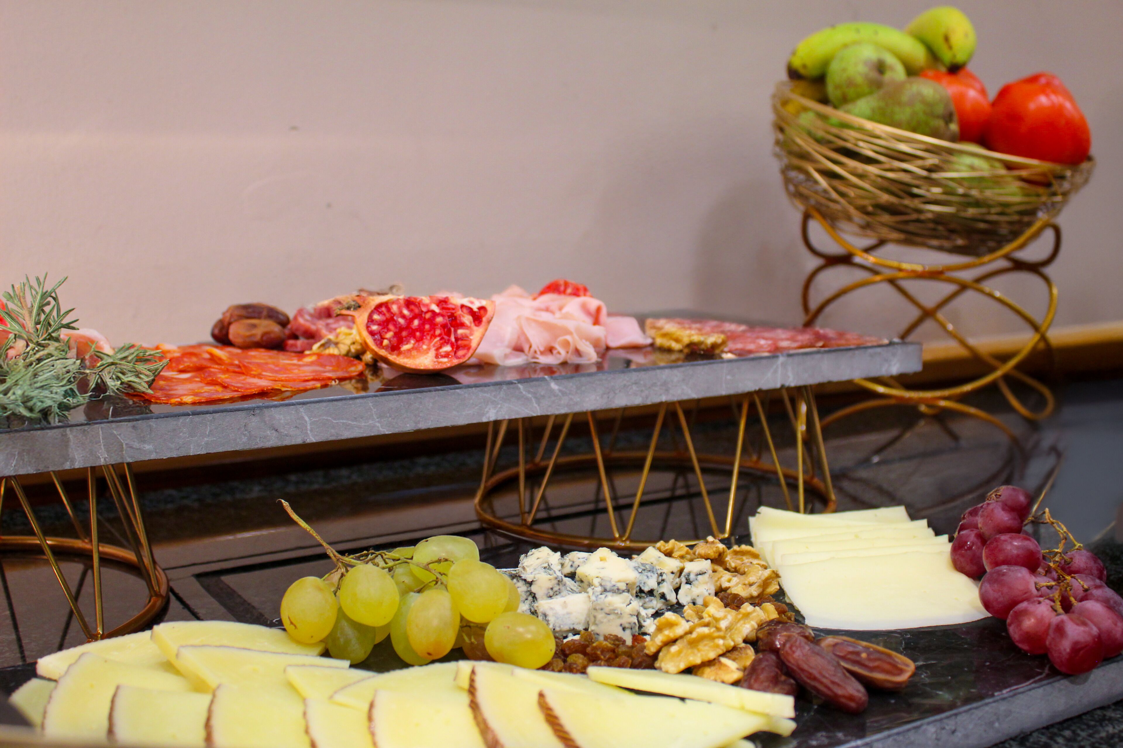A charcuterie board with various cheeses, fruits, and nuts.