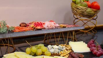 A charcuterie board with various cheeses, fruits, and nuts.