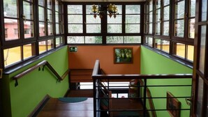 A staircase with a green wall and wooden railings, leading to a lower level. - Hotel Benzúa (Llanes)