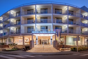 A multi-story hotel with balconies, a central entrance, and a sign reading 'HOTEL COSTA BRAVA'. - Hotel GHT Costa Brava & SPA (Tossa de Mar)