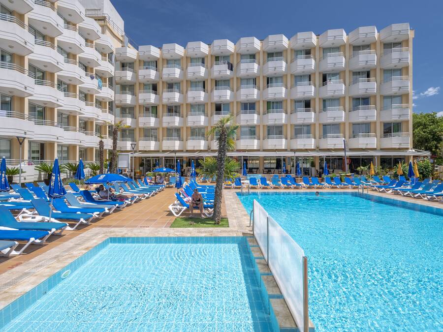 Una piscina techada, una piscina al aire libre, sombrillas