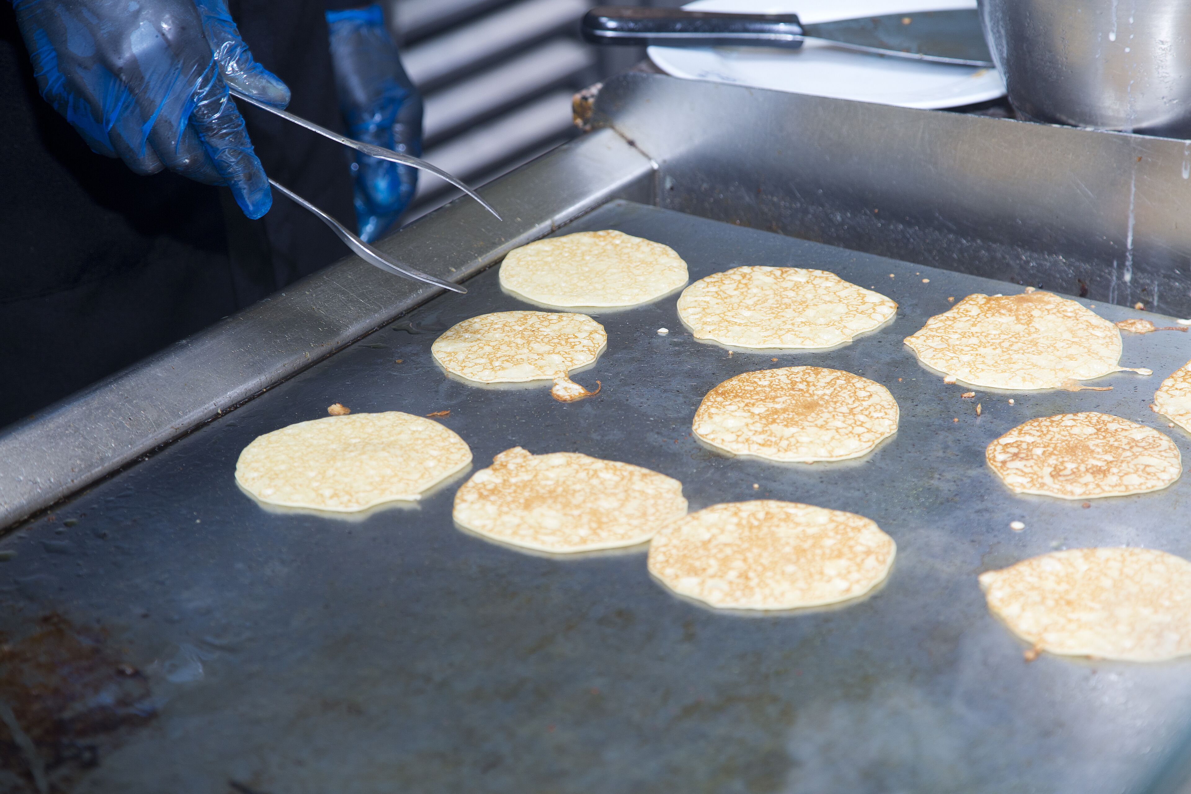 Pancakes being cooked on a griddle.
