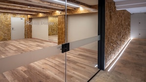 Ein geräumiger Raum mit Holzboden, einer Glasscheibe und einer Steinwand.