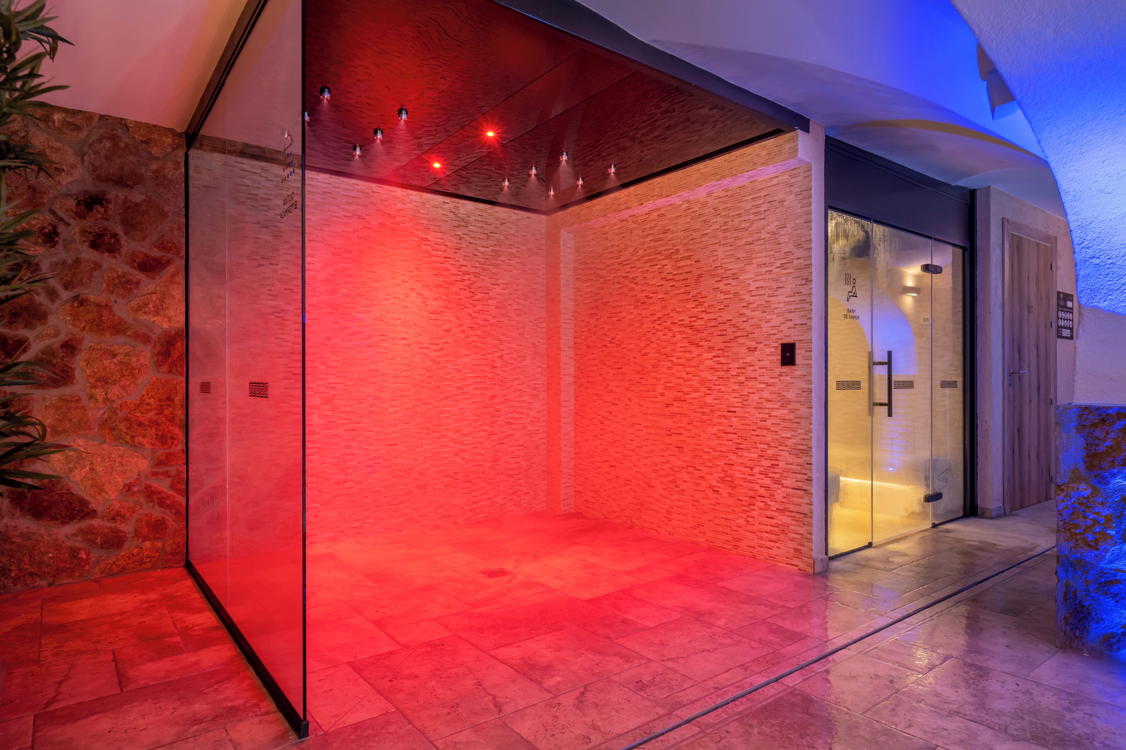 A modern elevator with a glass enclosure and a red-lit interior.