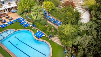 Alberca al aire libre, sombrillas en la alberca y camastros