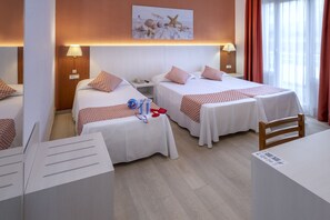 A hotel room with two single beds, a desk, and a chair.