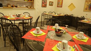 A dining area with round tables, black chairs, and red placemats. - Hôtel de France (Béziers)