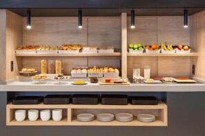 A buffet setup with various food items and condiments. - Hotel Savoy (Antibes)