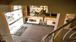 A hotel lobby with a reception desk, a sofa, and a staircase. - Ligure Cannes (Cannes)