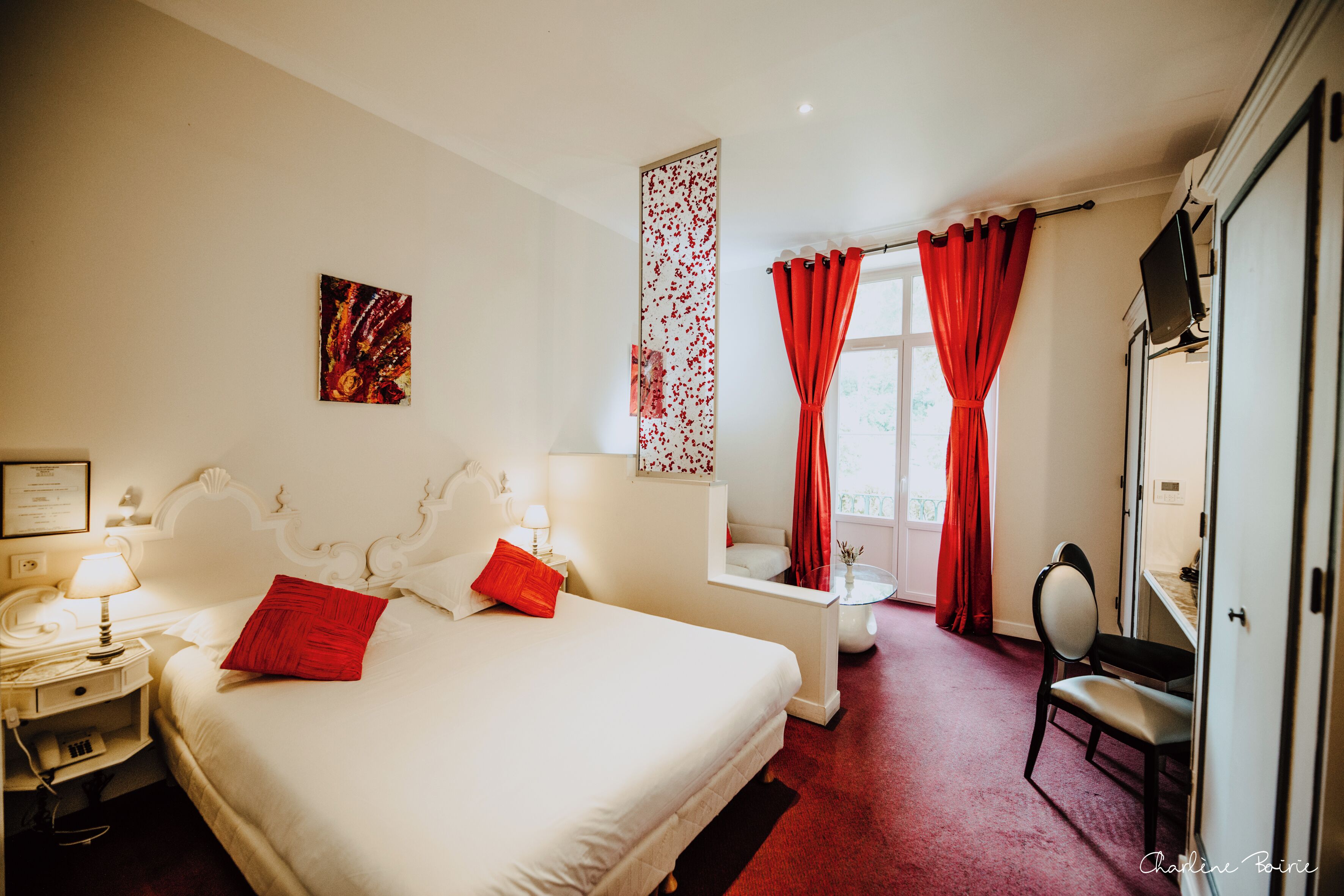 Una habitación de hotel con una cama, un escritorio, una silla y un televisor.