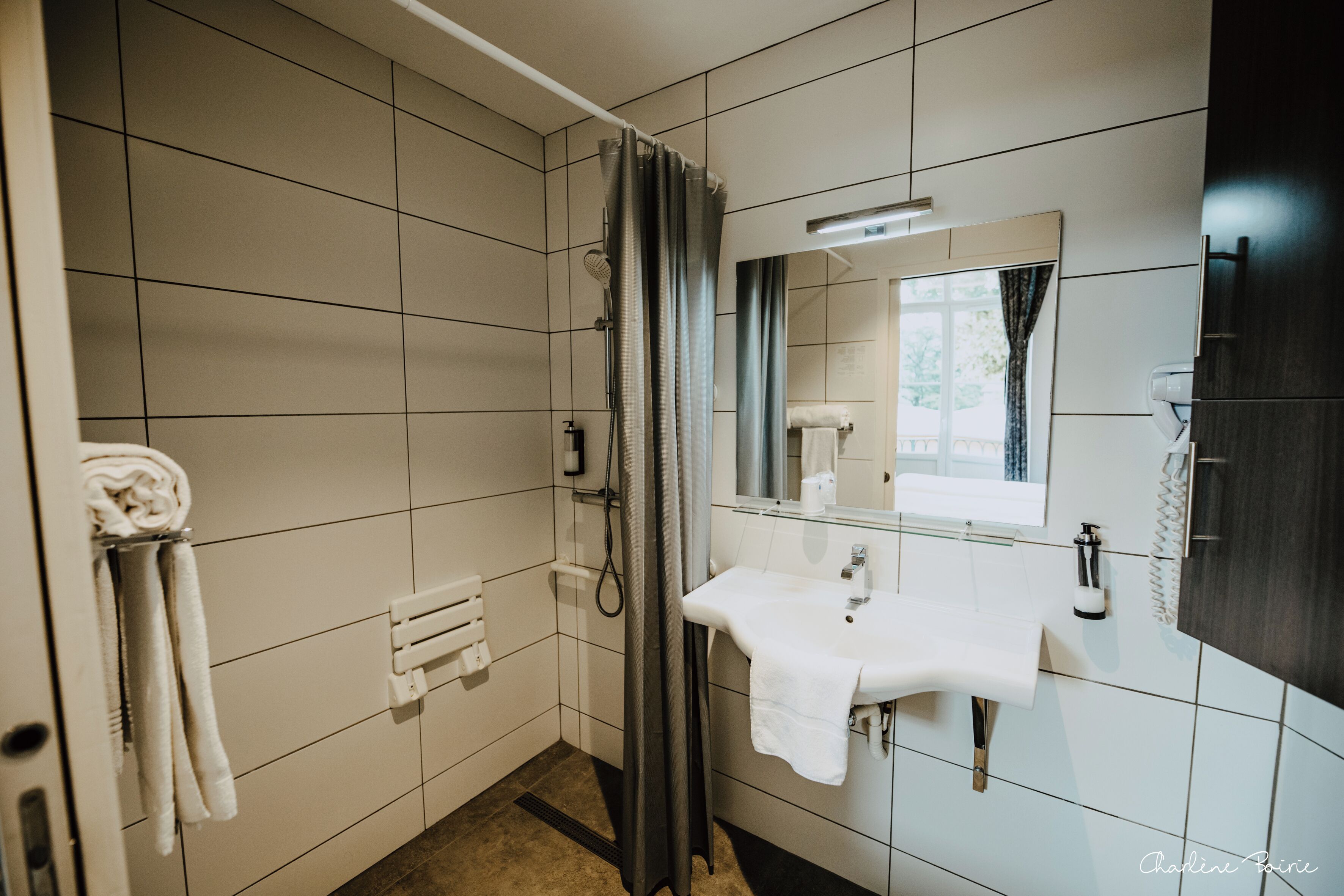 A modern bathroom with a shower, a sink, and a mirror.