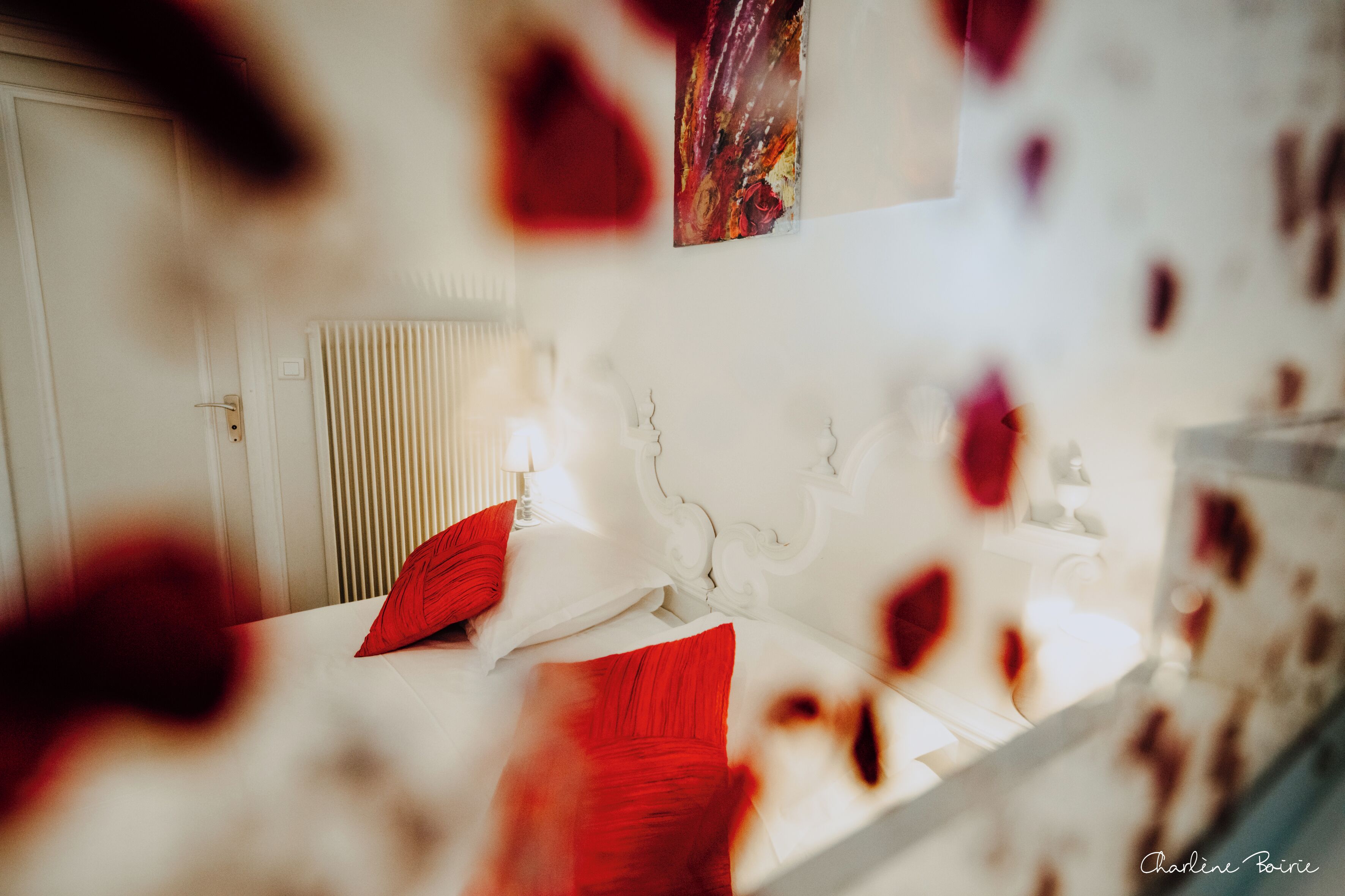 A bedroom with a bed, pillows, and a wall-mounted artwork.
