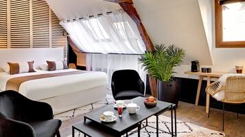 Een gezellige slaapkamer met een bed, een bijzettafeltje met theeservies, en een zithoek met stoelen en een plant.