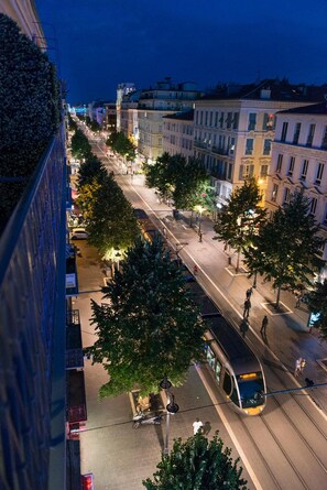 A nighttime urban street scene with tram lines, buildings, and trees. - Hotel 64 Nice (Nice)