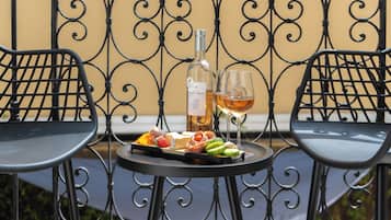 Uma mesa com uma garrafa de vinho, dois copos e uma tábua de frios.