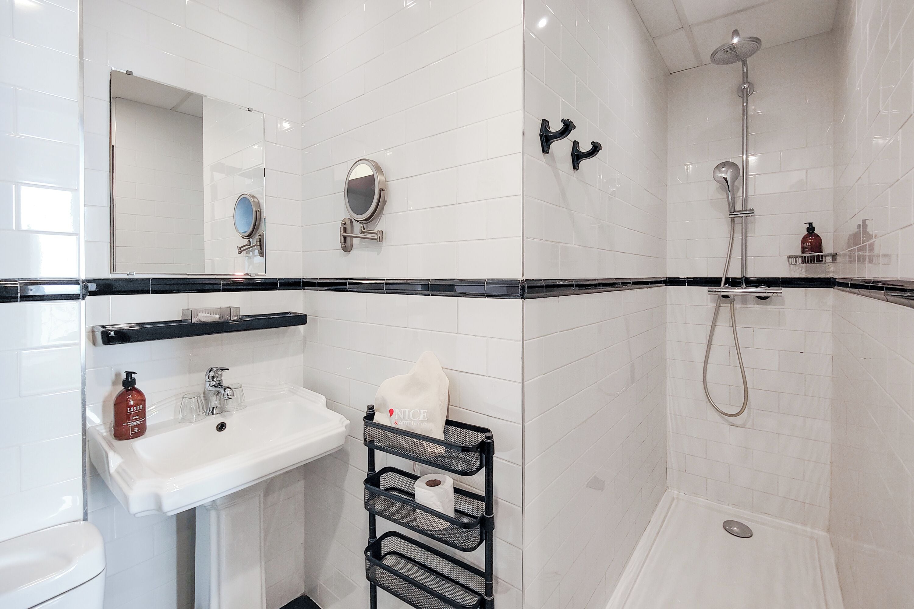A modern bathroom with a white sink, mirror, and shower.