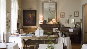 A dining area with a piano, a large mirror, and a chandelier. - Villa Rivoli (Nice)