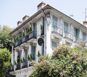 A historic building with multiple balconies, ornate architectural details, and a sign indicating it is a hotel. - Villa Rivoli (Nice)