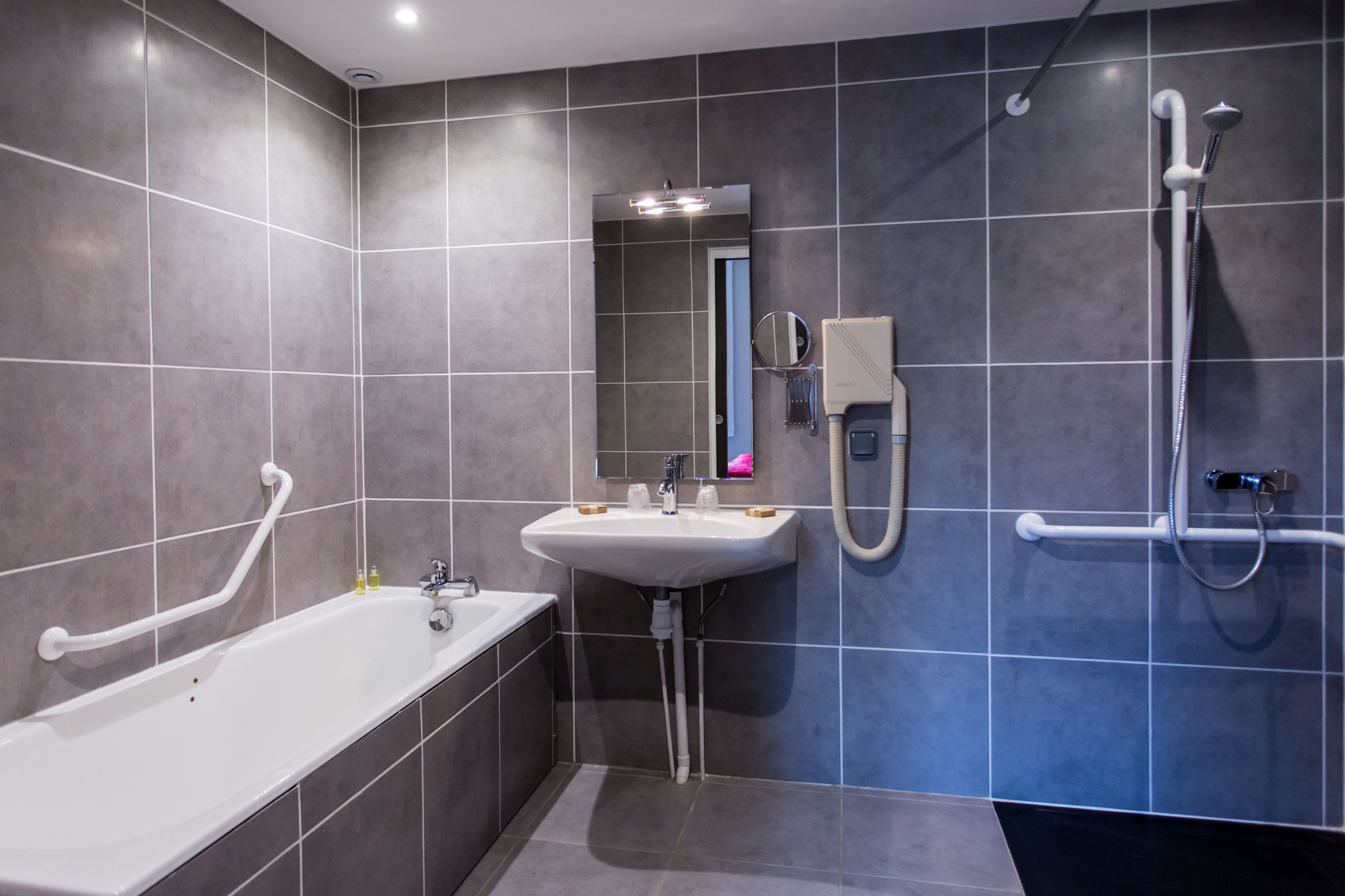 Un baño moderno con bañera, lavamanos y ducha.