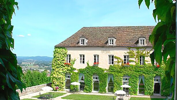 A large building with a symmetrical facade, multiple windows, and a central courtyard with a gravel path. - Les Ursulines (Autun)