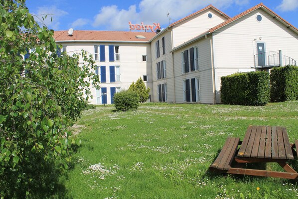 A building with a red-tiled roof, multiple windows, and a balcony. - greet Hotel Dijon Sud Longvic (Longvic)