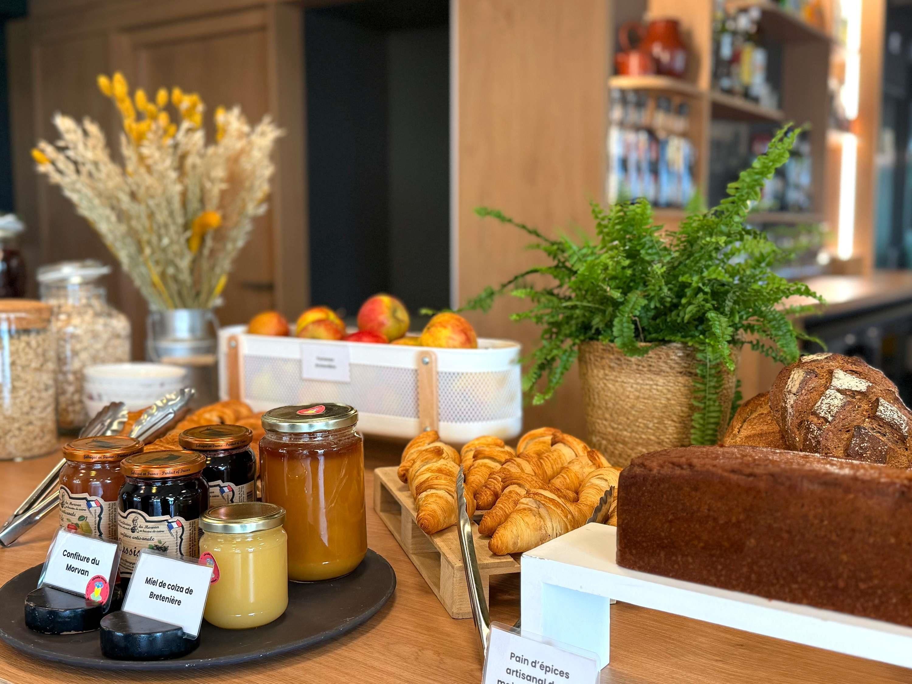 A breakfast buffet with pastries, bread, and jams.