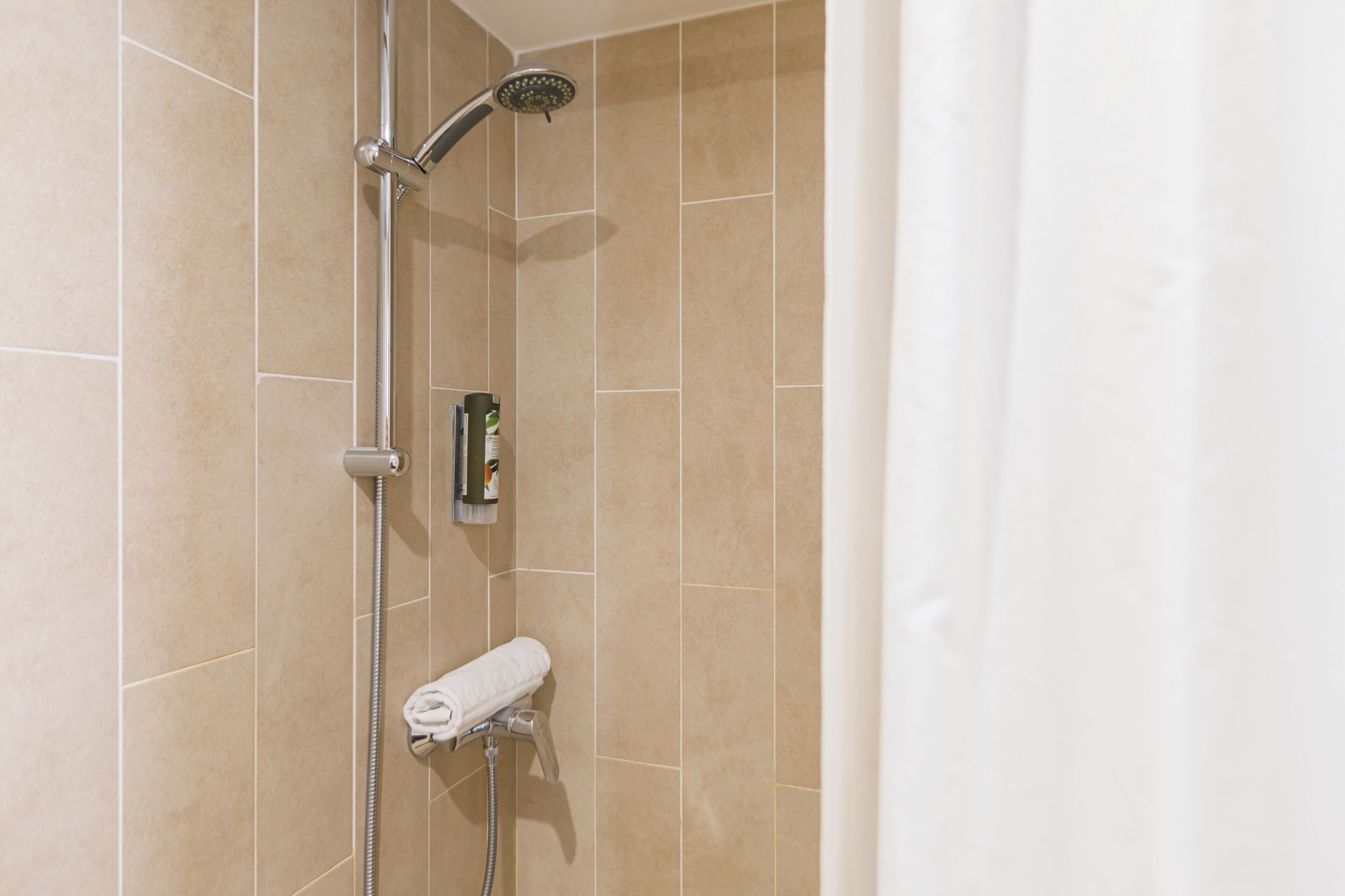Ducha con cabezal de ducha de mano y grifo empotrado.