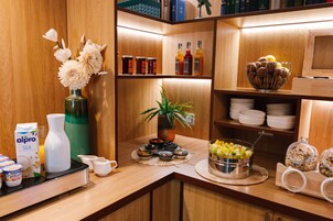 Un'area buffet ben organizzata con diverse pietanze, condimenti e una selezione di bevande.