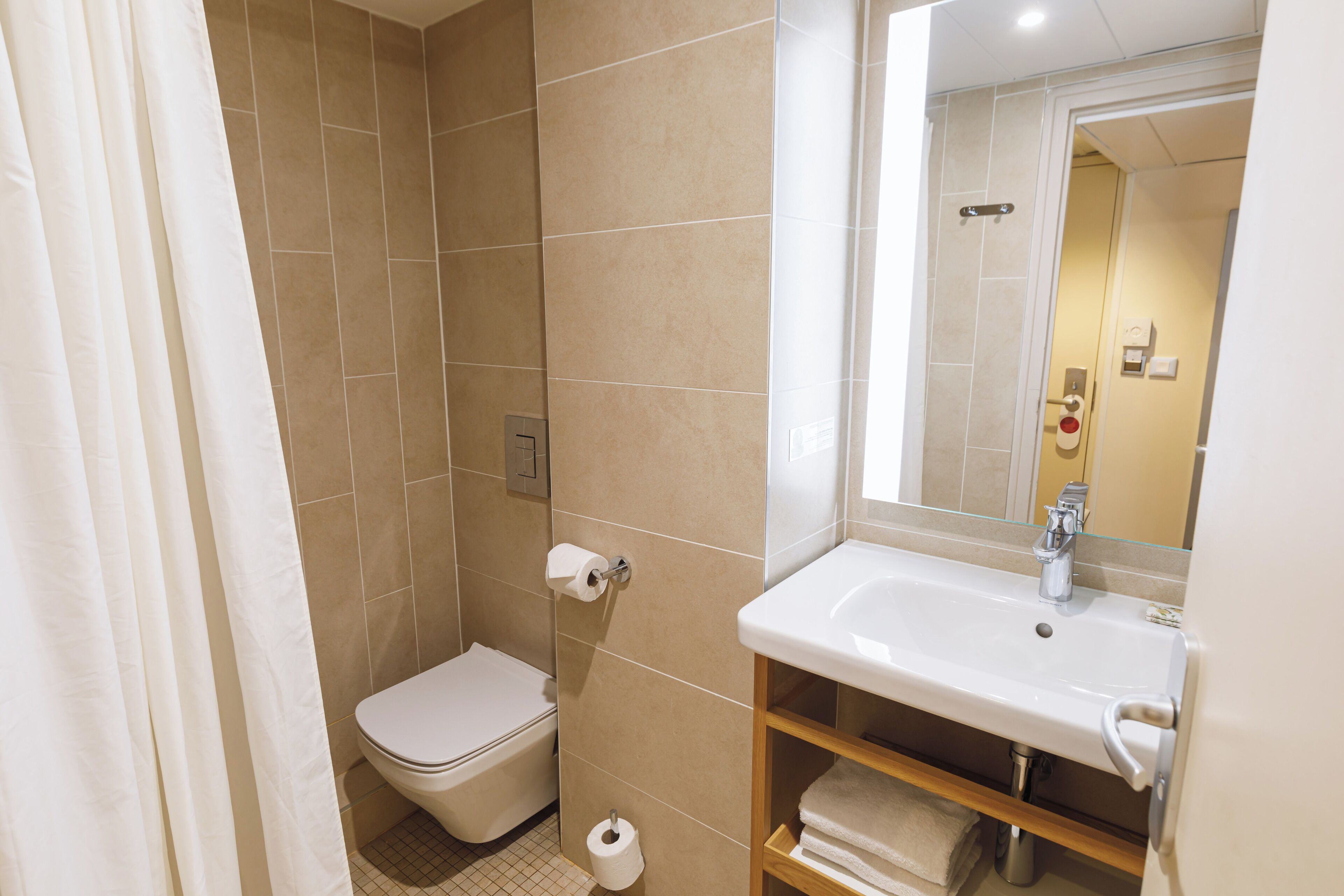 Baño con inodoro, ducha y lavamanos.