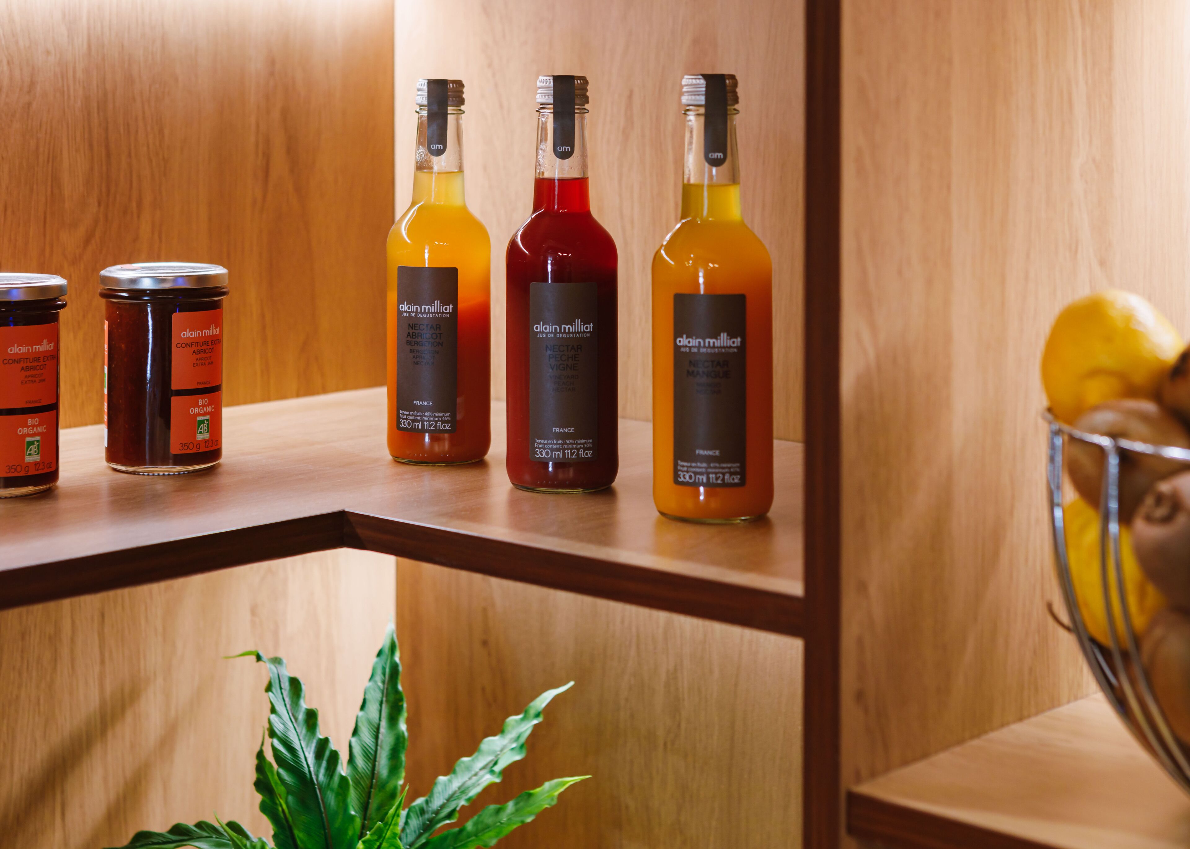Un estante de madera con varios frascos y botellas, incluyendo un recipiente metálico y una planta.