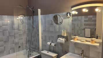A modern bathroom with a glass-enclosed shower, a toilet, a sink, and a vanity with a mirror.