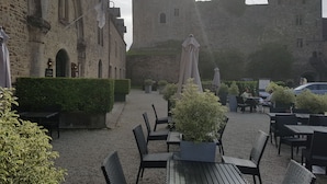 Een binnenplaats met buitenplaatsen, stenen gebouwen en een toren.