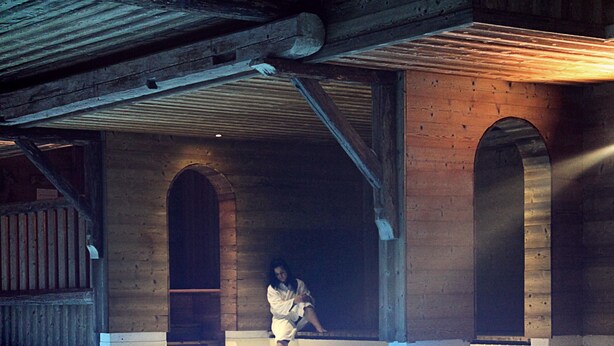 A swimming pool with wooden beams and arched doorways.