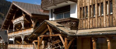 Un edificio de madera tradicional con varios balcones y ventanas grandes, probablemente un hotel o casa de huéspedes en una zona montañosa.