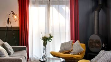 Una sala de estar moderna con un sofá, un sillón y una pequeña mesa con un florero.