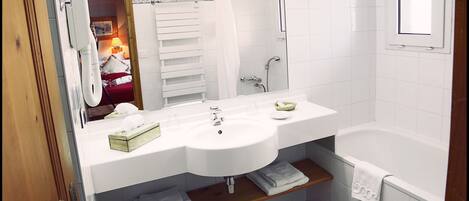 Un baño con lavabo, espejo y bañera.