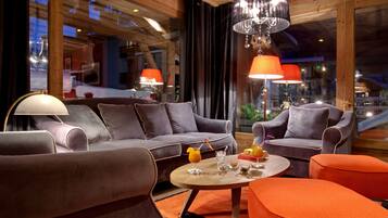 A modern lounge area with a sofa, armchairs, and a coffee table.