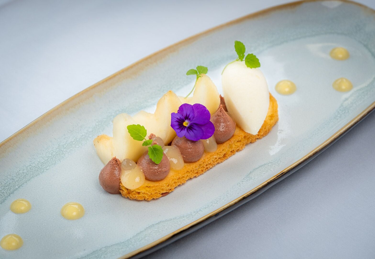 Un postre en un plato de cerámica con textura suave y un esmalte azul claro.