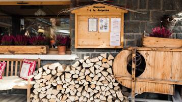 Een houten bord met 'Bienvenue à la Griyotire' en een stapel haardhout.