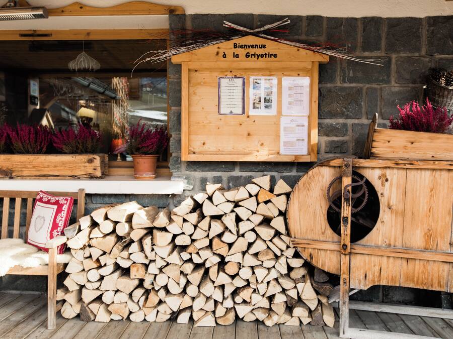 Een houten bord met 'Bienvenue à la Griyotire' en een stapel haardhout.