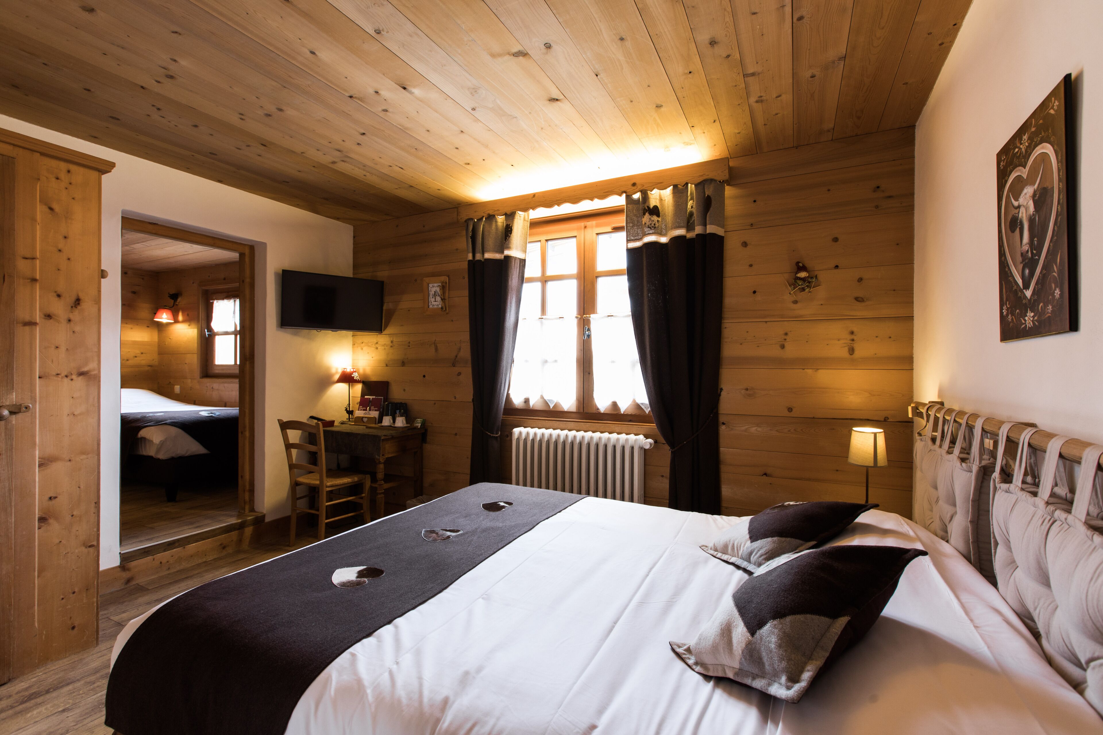 Una habitación de madera con una cama, un escritorio y una silla.