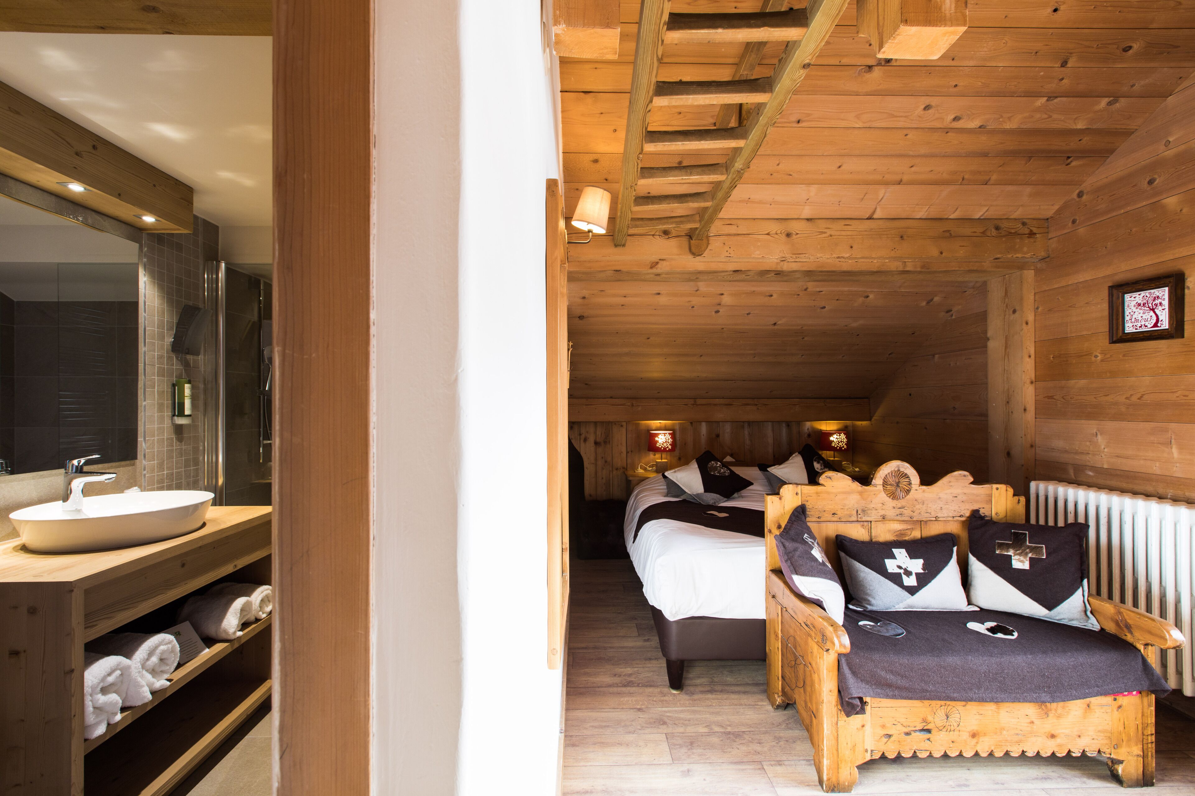 Ein Holzblockhaus innen mit Bad, Bett und einer hölzernen Bank.