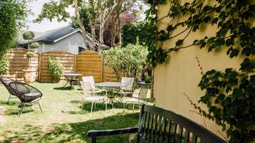 Une terrasse avec une clôture en bois, une table avec des chaises et un banc.